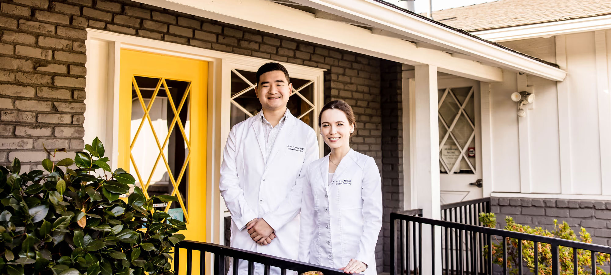 A well-lit reception area with a desk, computer monitor, and potted plant.
